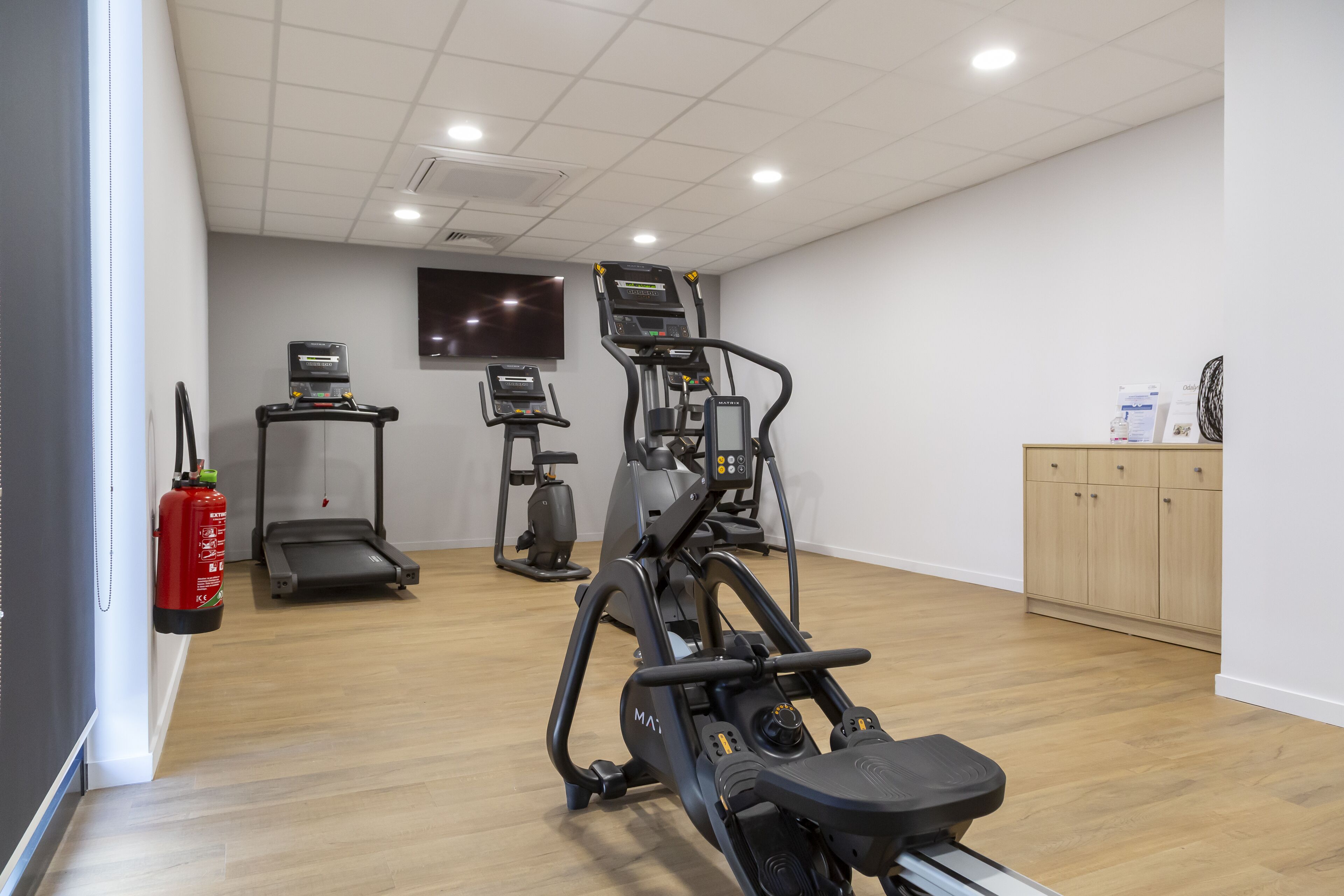 Ein Fitnessraum mit Laufbändern, Crosstrainern und einem stationären Fahrrad.