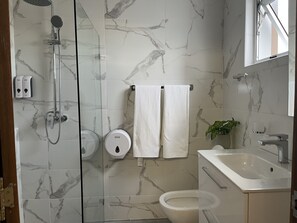 Douche, serviettes fournies, savon, shampoing