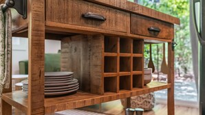 A wooden table with drawers and shelves, holding plates and a salt shaker. - Chic PRIVATE cabin in the woods --> queen bed, deck, high-speed Wifi (Greenville)