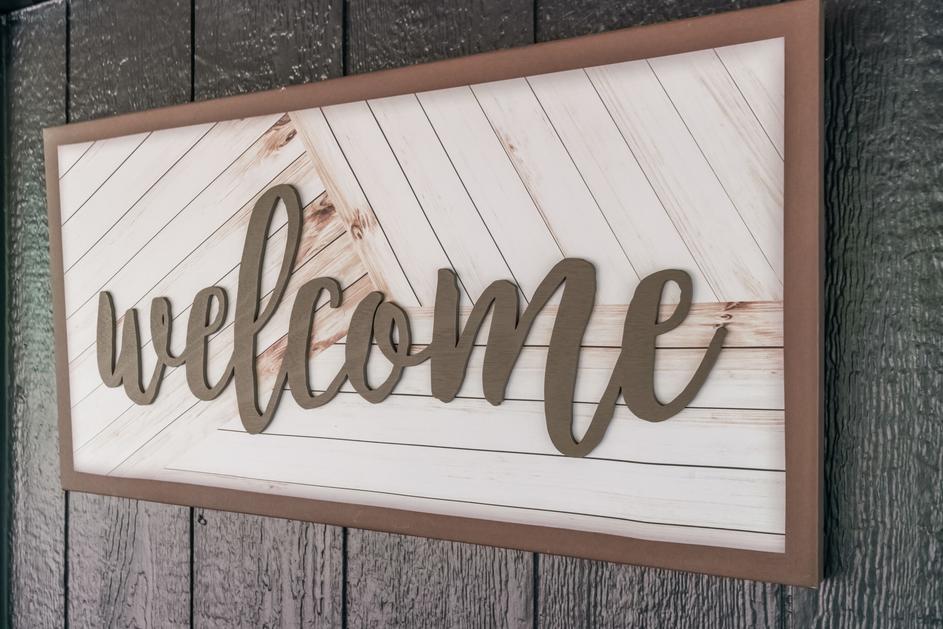 Un letrero de madera con la palabra 'welcome' en letras grandes.