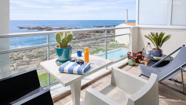 A balcony with a view of the sea, a pool, and potted plants. - Oceanfront studio with swimming pool in La Chaume (Les Sables-d´Olonne)