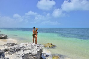 A couple standing on a rocky outcrop overlooking a clear blue sea. - Fanthakstico Apart Vista al Mar Cancun (Cancun)