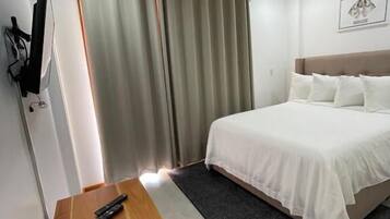 Desk, laptop workspace, iron/ironing board, bed sheets