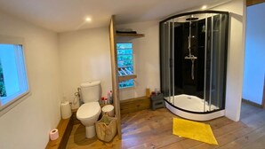 Un baño moderno con ducha, inodoro y ventana.