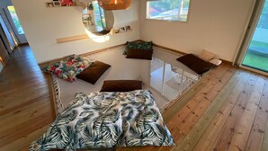 Una habitación con cama, lámpara colgante, ventana y vistas al exterior.