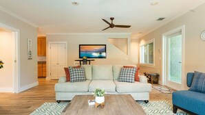 A modern living room with a sofa, coffee table, and a ceiling fan. - OFF THE HOOK - 3 Bedroom / 3 Bathroom W/ Pool & Parking (Key West)