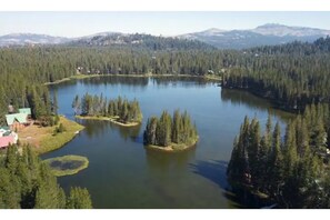 Surrounded by dense forest and majestic mountains, this serene lakeside setting offers breathtaking views of the tranquil lake and its small islands.