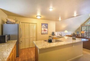 Enjoy cooking in this well-equipped kitchen with a central island, sink, and microwave.