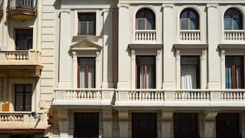 A multi-story building with classical architecture, featuring arched windows and decorative balustrades.