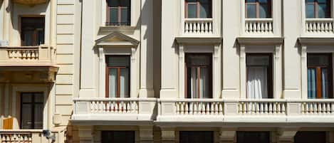 Un edificio de varios pisos con arquitectura clásica, que presenta ventanas en arco y balaustradas decorativas.