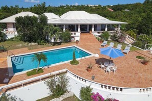 A pool area with a tiled deck, lounge chairs, and a covered patio. - Les Zephyrs (3 bedrooms) - Villa with pool near beaches, Terres Basses, St. Martin (Terres Basses)