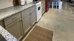 A modern kitchen with granite countertops, stainless steel appliances, and a red refrigerator. - Former car wash bay apt. Unique!! (Mountain Home, Ar, 72653)
