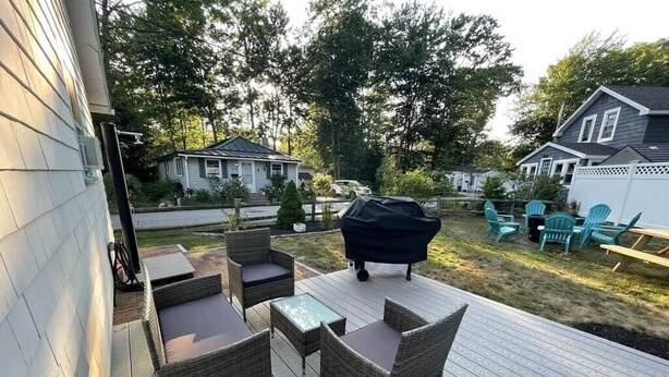 A deck with wicker furniture and a barbecue grill.