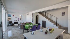 Eine moderne Küche mit Essbereich, einer Treppe und einem Wohnzimmer.