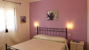 Une chambre à coucher avec un lit, une table de chevet et des lampes fixées au mur.