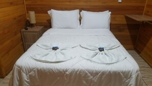 A double bed with white bedding and a wooden headboard. - Pousada Rio Túnel (Grão Pará)