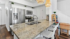 A modern kitchen with stainless steel appliances, granite countertops, and a built-in sink.
