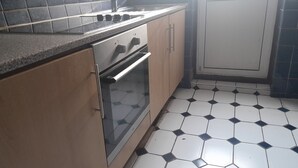 A kitchen with a gas stove, oven, and tiled floor. - Lovely 1-bed Studio in London (London)