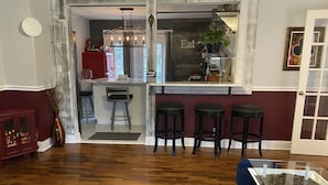 Une cuisine moderne avec un coin bar, un plancher en bois et un tapis à motifs bleus.