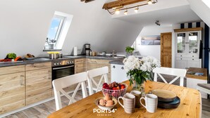 Cozinha moderna com armários de madeira, mesa de jantar com cadeiras e uma fruteira.