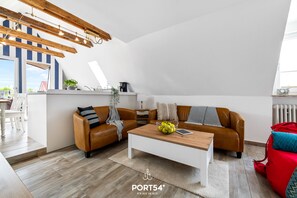 Un salon moderne avec un plafond en bois, un canapé en cuir marron, une table basse blanche et un sac rouge.