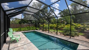 Une piscine extérieure couverte offrant une vue dégagée sur la végétation environnante, avec une clôture en bois en arrière-plan.