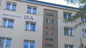 Un immeuble à plusieurs étages portant l’enseigne « WASZYNGTONA 25A », qui indique l’adresse.