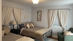 A bedroom with two beds, a nightstand, a lamp, a chair, and a painting on the wall. - Daybreeze Vacation Home w/ Hot Tub & Gorgeous View (Homer)