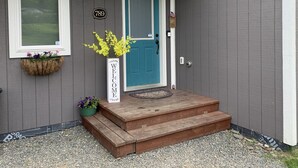 A house with a teal door, a welcome sign, and a mailbox. - Daybreeze Vacation Home w/ Hot Tub & Gorgeous View (Homer)