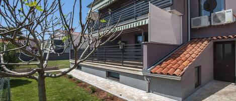 A modern house with a sloped roof, satellite dish, and air conditioning units.