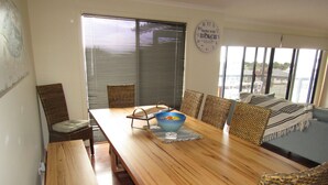 A dining area with a wooden table, wicker chairs, and a bowl of fruit. - Lady Doris,  wifi  - Off Peak Special! (Port Vincent)