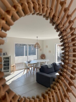 Uma sala de estar moderna com área de jantar, um sofá e uma mesa.
