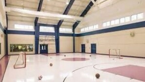 Eine Sporthalle mit Basketballfeld, Volleyballfeld und einer Kletterwand.