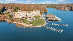 Un hotel con diversi edifici, un molo con barche e un lago.