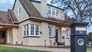 A two-story house with a bay window, a front door, and a mailbox with the number 16. - 3BR Family Home Sleeps 6 – Fireplace, Spa Bath, Near Blue Lake | Ideal for Extended Stays (Mount Gambier)