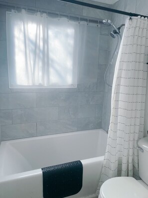 Combined shower/bathtub, towels, soap, toilet paper