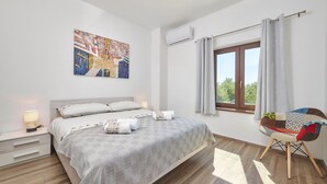 A bedroom with a bed, bedside table, and a chair.