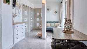 Un salon moderne avec un canapé, une table basse et un téléviseur fixé au mur.