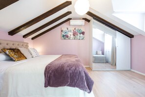 A bedroom with a bed, a ceiling fan, a painting, and a sliding door leading to another room.