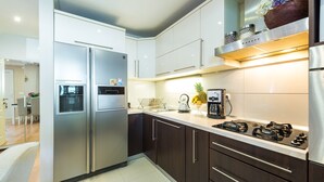 A modern kitchen with stainless steel appliances, dark wooden cabinets, and a gas stove. - Luxury House Anita in old Town Cavtat-beachfront (Konavle)