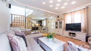 A spacious living room with a sofa, coffee table, and a TV. - Luxury House Anita in old Town Cavtat-beachfront (Konavle)