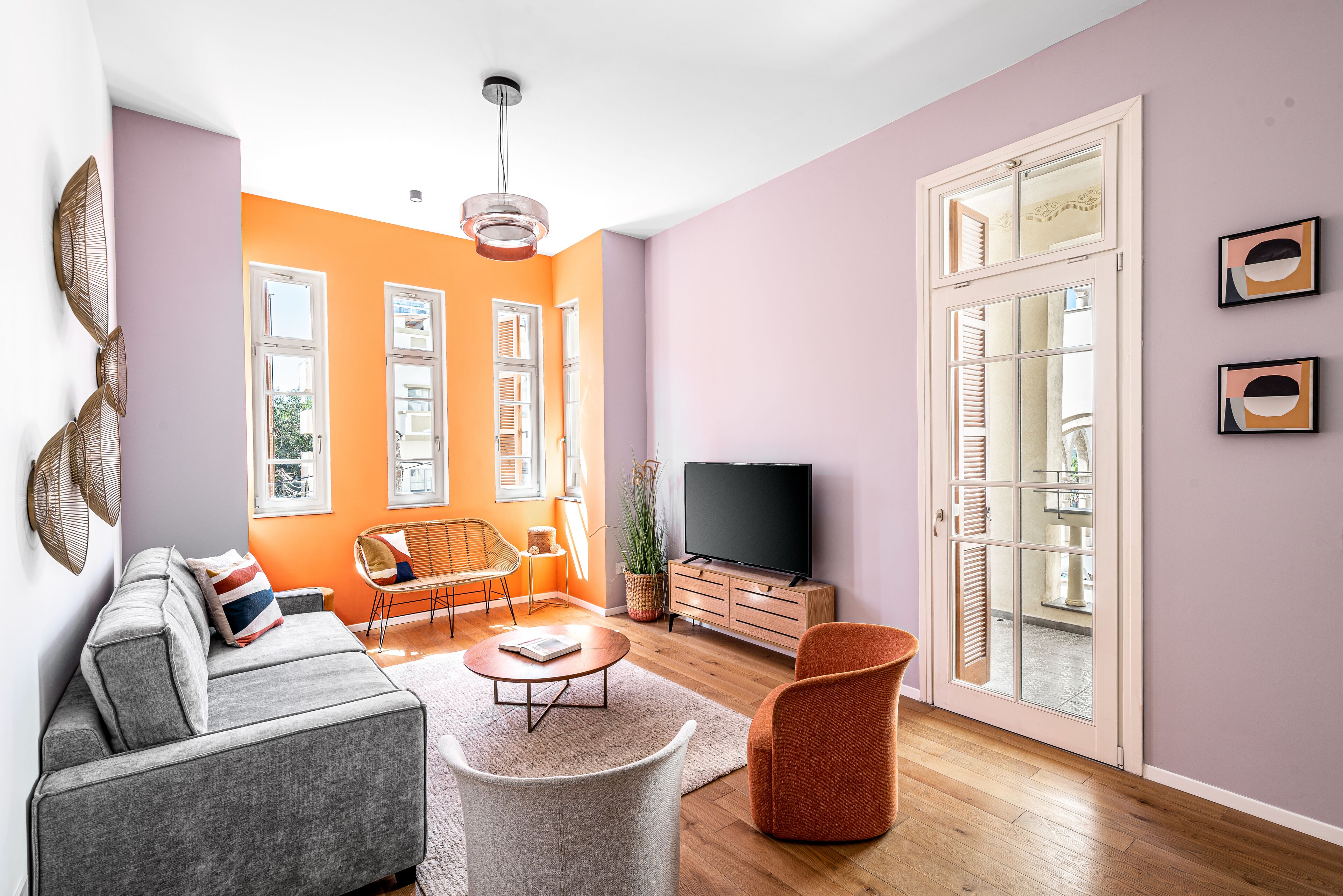 Uma sala de estar com sofá, mesa de centro e paredes laranja.