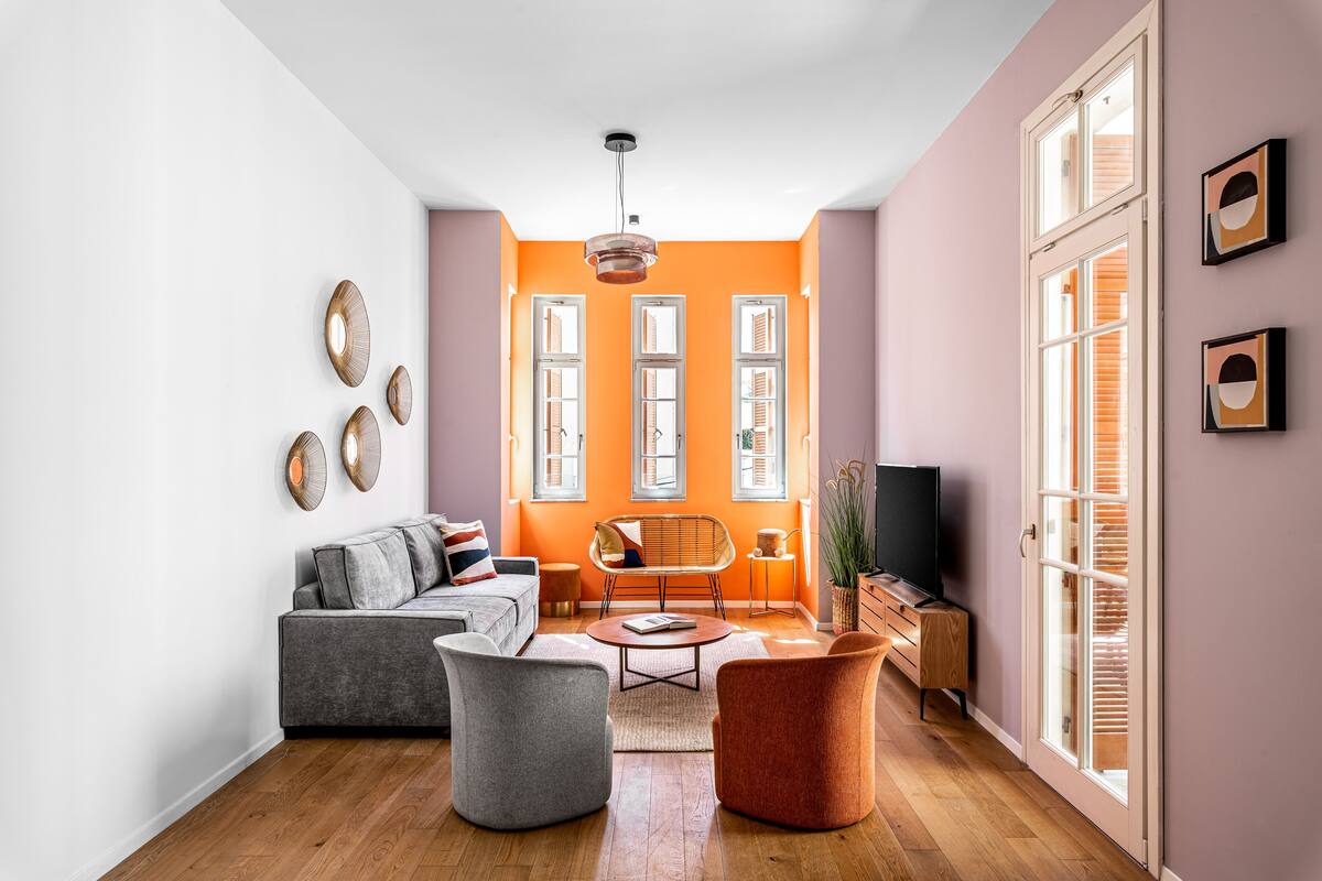 A living room with a sofa, armchairs, a coffee table, and a television.