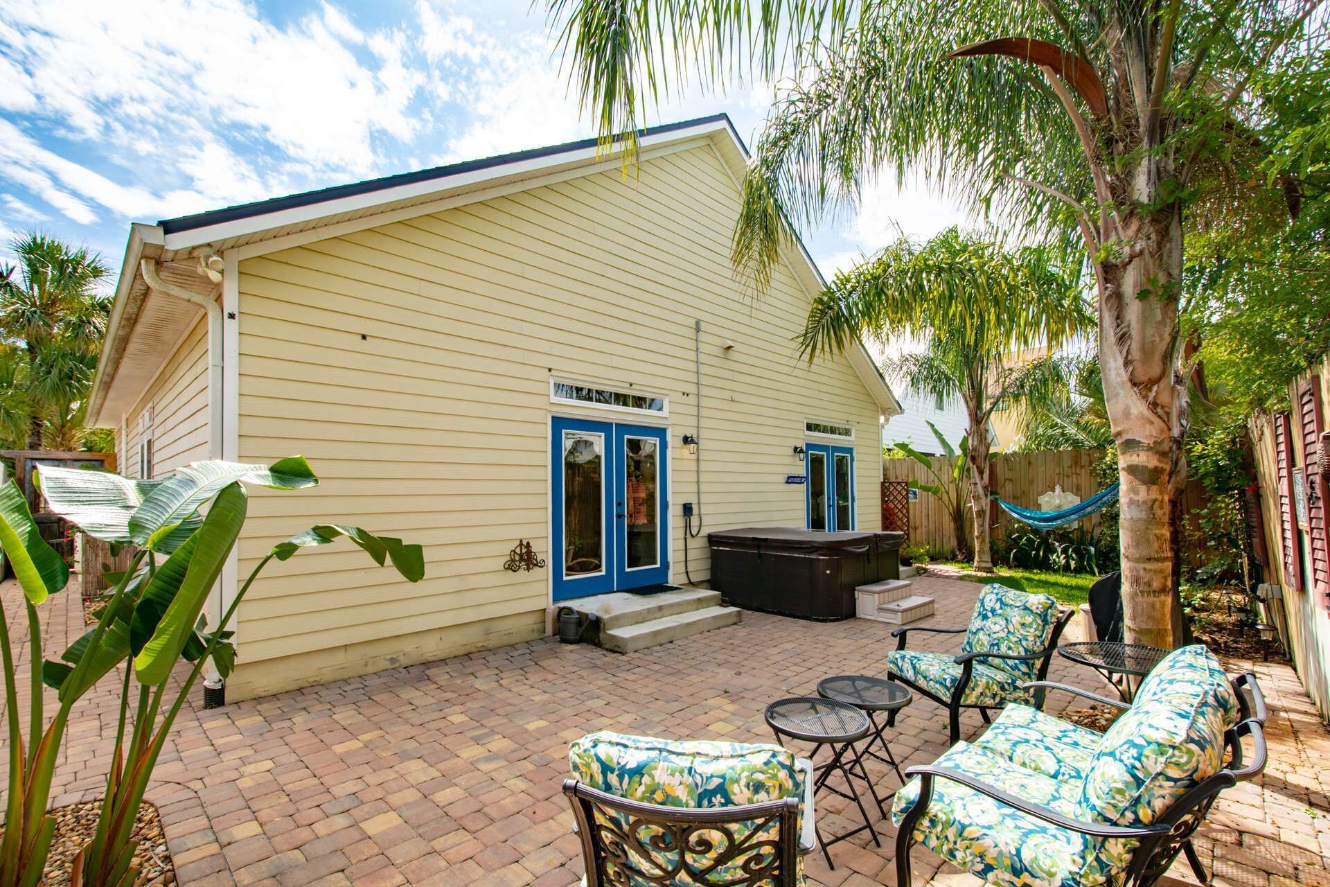 A house with a patio area featuring outdoor furniture and a hot tub.