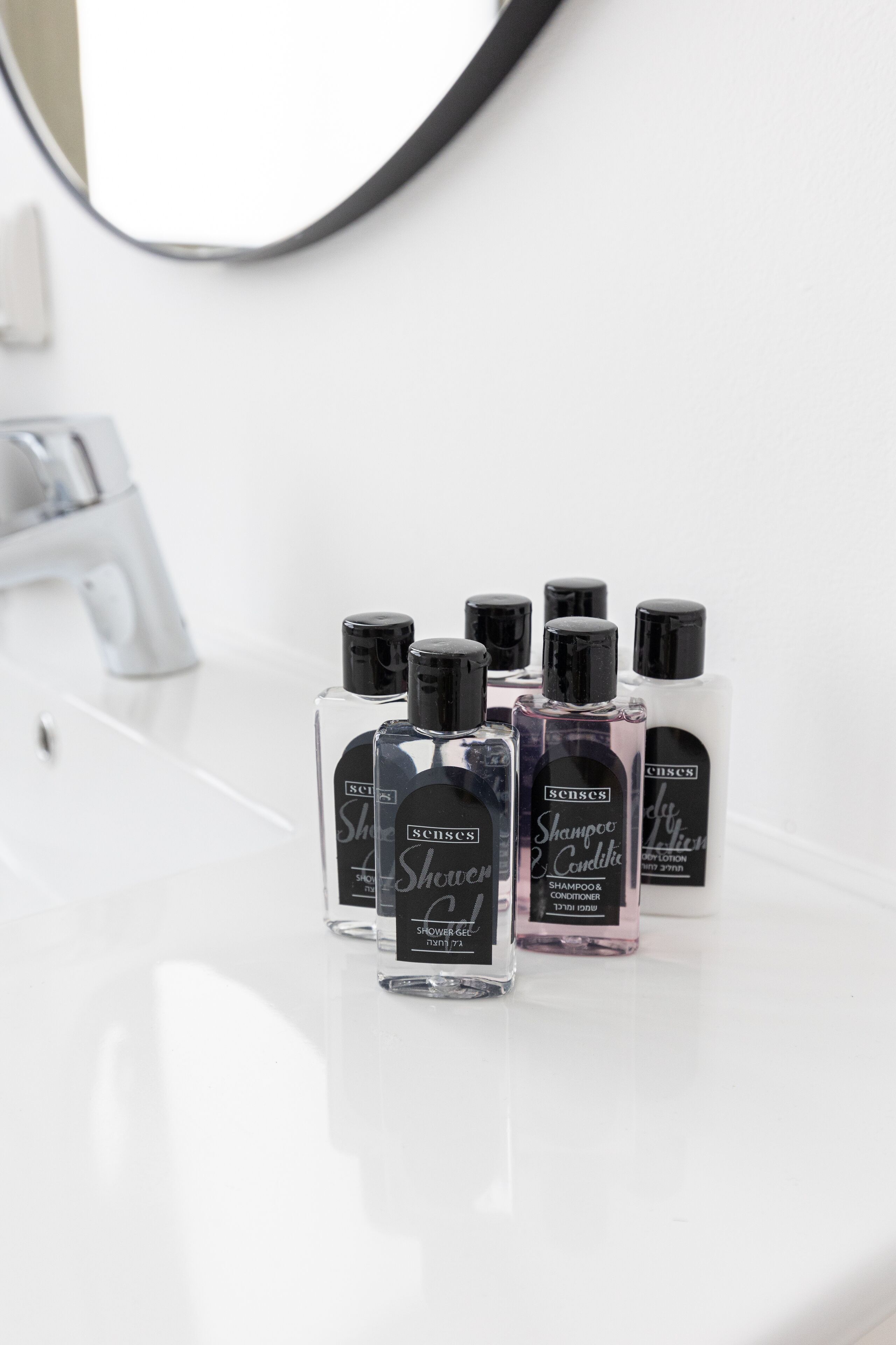 A bathroom with a white sink and several bottles of hair care products.