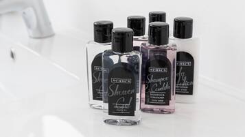 A bathroom with a white sink and several bottles of hair care products.