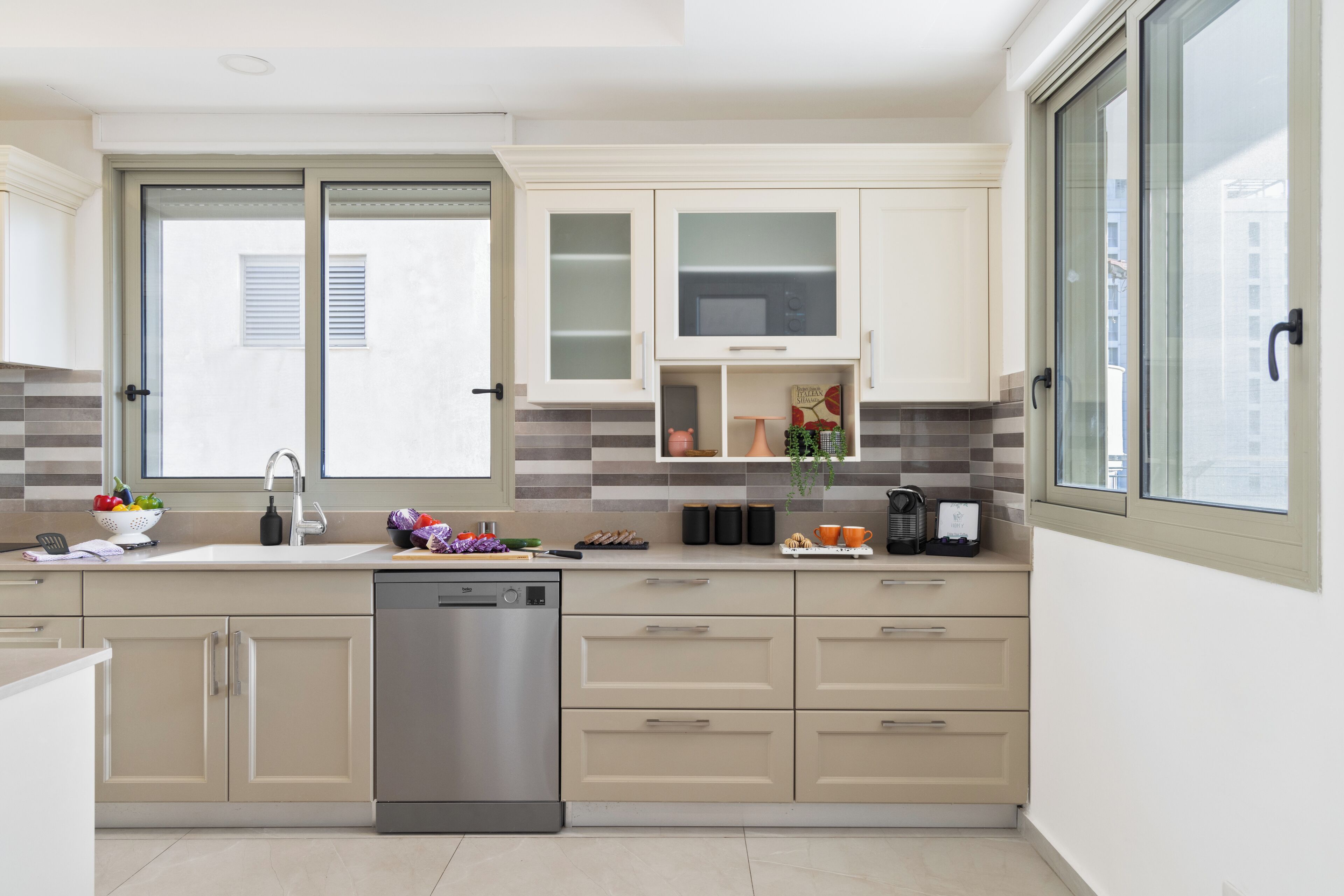 Una cocina moderna con lavavajillas, puertas dobles y ventana.
