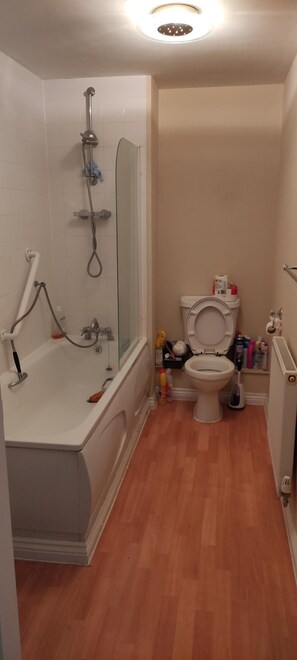 A bathroom with a bathtub, toilet, and shower.