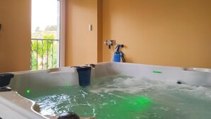A hot tub with a view of a balcony and greenery outside. - Lou Vachou - Rimeize (RIMEIZE)