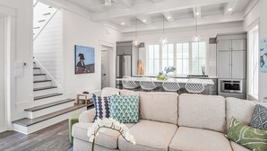 A modern kitchen with a central island, white cabinetry, and pendant lighting. - Isle of Dogs 205 Fiv-b (Port Aransas)